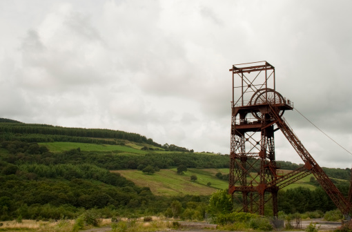 A classic welsh scene of a colliery against green hills and an overcast sky
