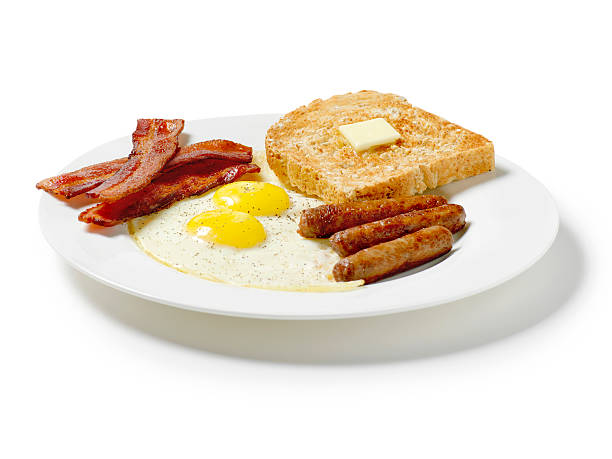 жареные яйца и тосты, завтрак, колбаски, бекон и полосками - sunny side up стоковые фото и изображения