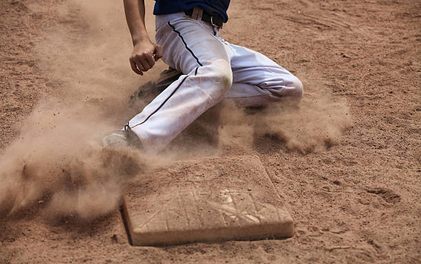 A man sliding into the base while playing ball stock photo