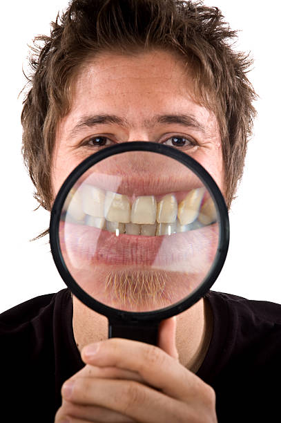 istock toothy smile with magnifying glass 176093410