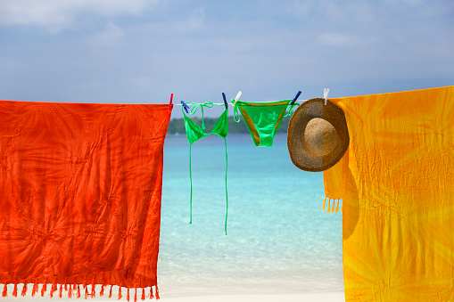 clothesline with sarongs and bikini on a tropical beach in the Caribbean