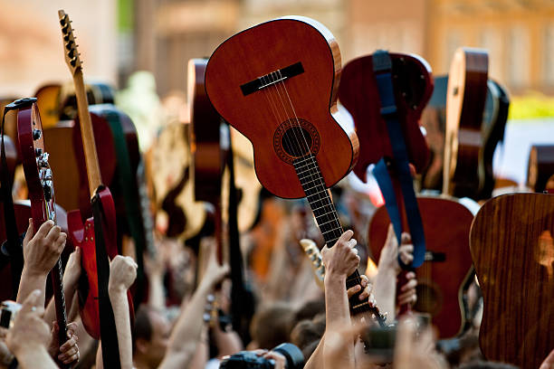 istock Crowded place with people playing on guitars 176095017