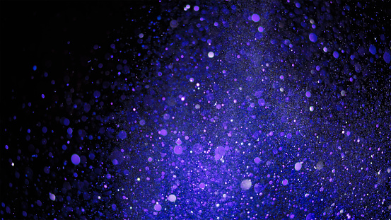 Close-up of purple and blue coloured glitter against black background.