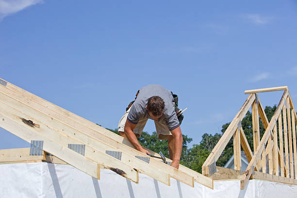 istock Builder Hammering Roof Truss Nail Against Blue Sky 176098323