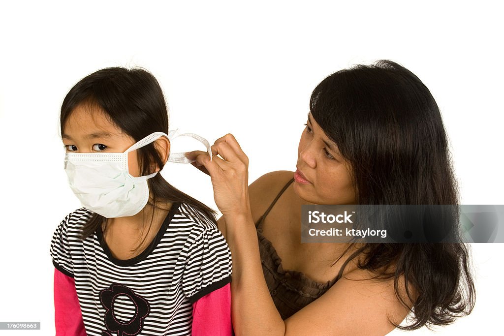 Mãe colocando máscara de menina - Foto de stock de 40-49 anos royalty-free