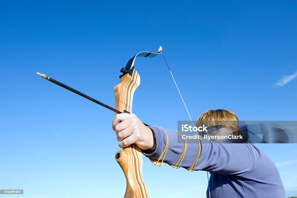 Archery. A mature woman takes aim with a bow and arrow.  Click to view similar images. 40-49 Years Stock Photo