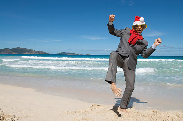istock Holiday Businessman in Santa Hat Dancing on Beach 176100037