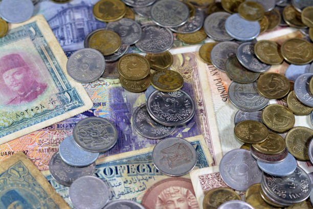Selective focus of old Egyptian money banknote bills and coins of different eras from kingdom to Republic of Egypt times, vintage retro old Egyptian currency, value, exchange rate of Egypt currency, selective focus enfoque selectivo de billetes y monedas de billetes de banco de dinero egipcio antiguo de diferentes épocas desde el reino hasta los tiempos de la república de egipto, moneda egipcia antigua retro antigua, valor, tipo de cambio de la moneda egipcia