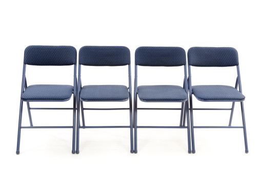 Row of four folding chairs isolated on white.Please also see: