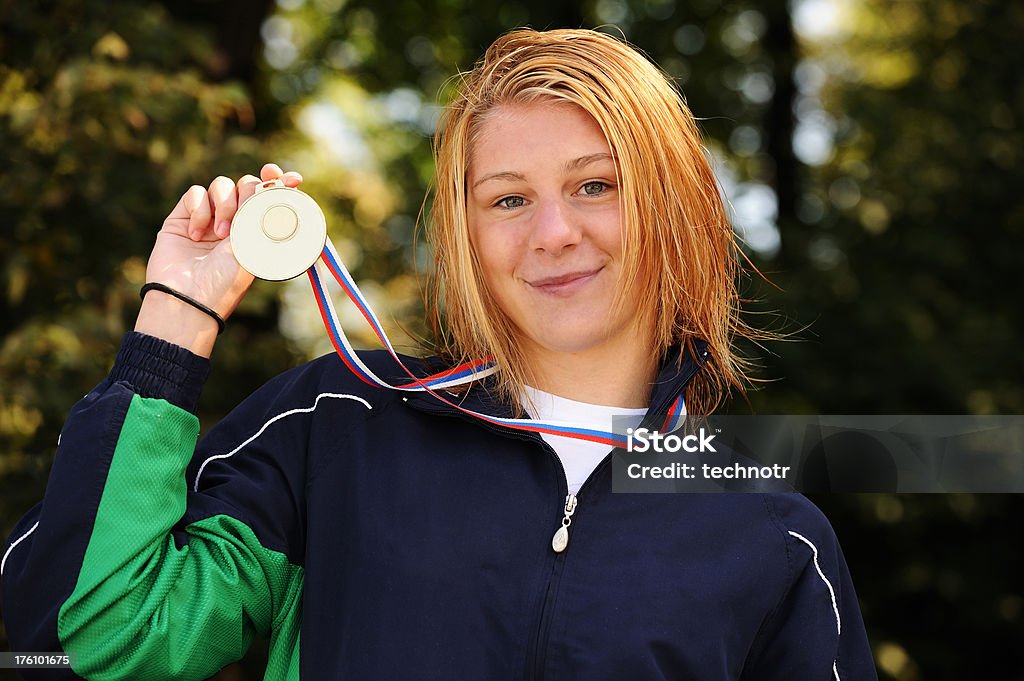 Swimming champion Portrait of young female swimmer showing her gold medal for the first place in 100 m freestyle race Teenager Stock Photo