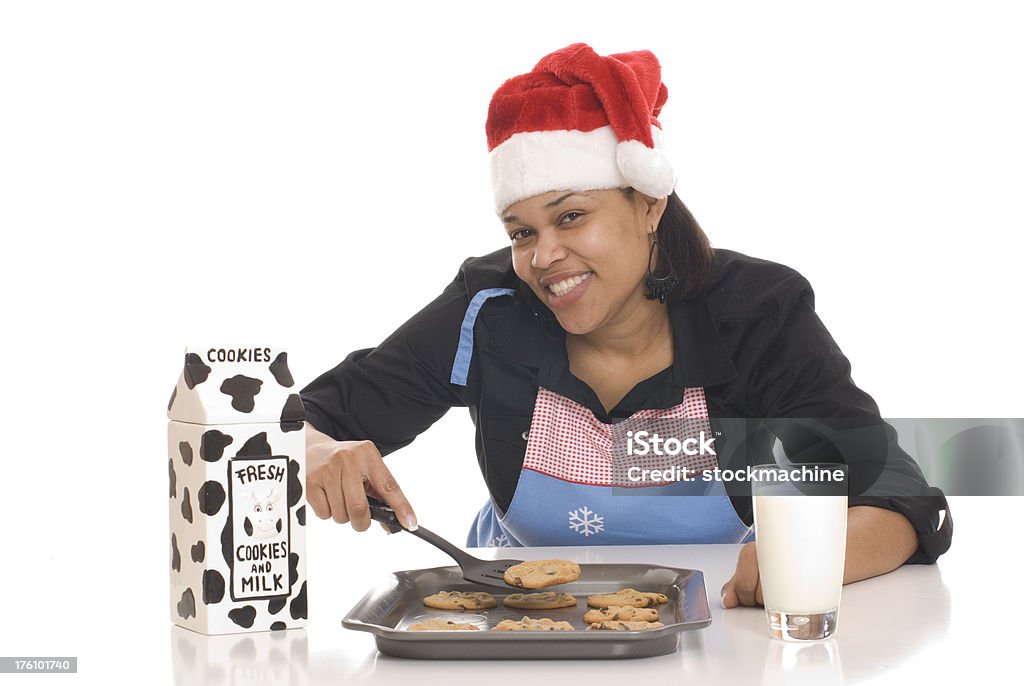 Holiday Cookies Young woman wearing Santa hat with  fresh baked cookies and milk. Isolated on white background. 20-24 Years Stock Photo