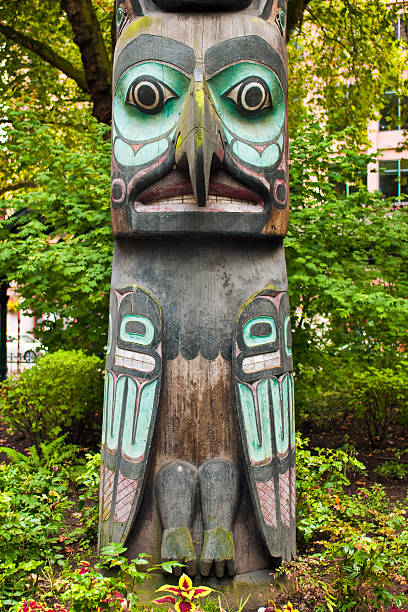 Totem pole at Pioneer Square in Seattle, WA "A totem pole of a bird in the Pioneer Square district of Seattle, WA. Other images of totem poles:" pacific northwest totem poles stock pictures, royalty-free photos & images