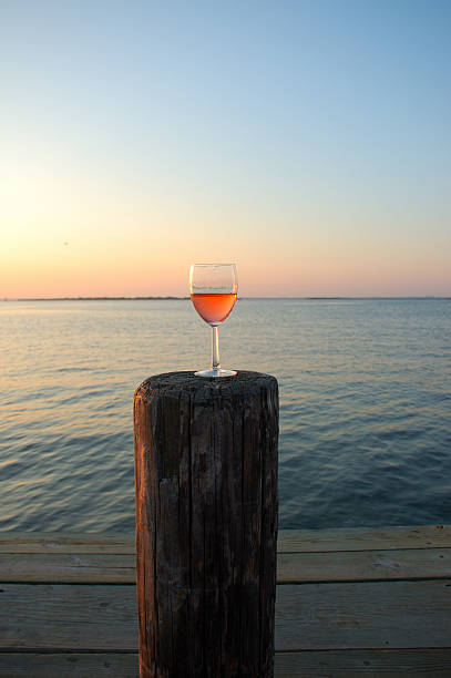 istock Rose Wine filled glass on bay pier at sunset 176101995
