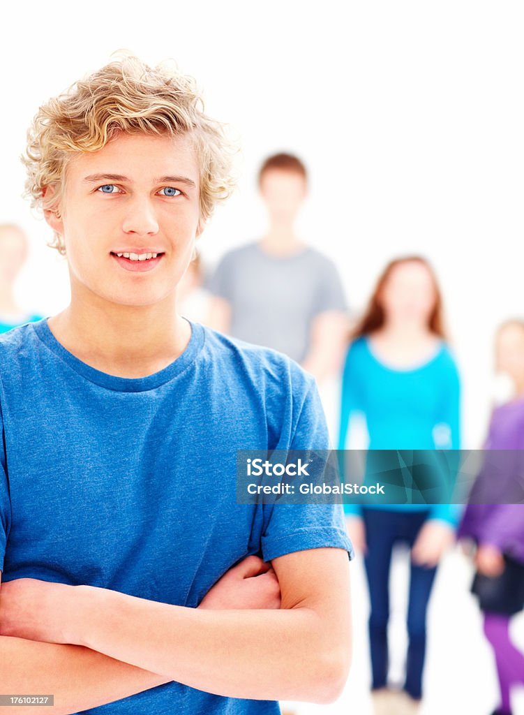 Closeup of a confident teenage boy with hands folded Closeup of a confident teenage boy with people at the background 16-17 Years Stock Photo