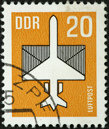 old East German airmail stamp with airplane and envelope.