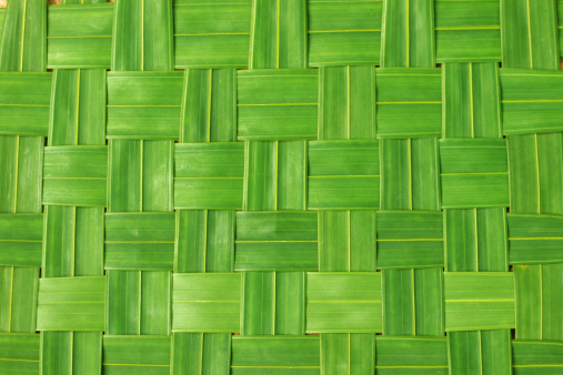 Green mat woven out of palm leaves.