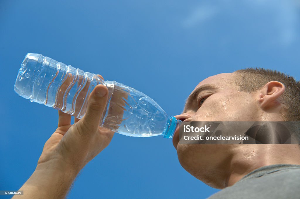 Испытыва�ющий жажду человек пьет - Стоковые фото Бутылка роялти-фри