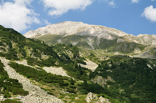 Panorama of beautiful Rila mountain landscape. Cloudy day. Wonderful time landscape in mountains. Mountain lakes, grassy field and rolling hills.