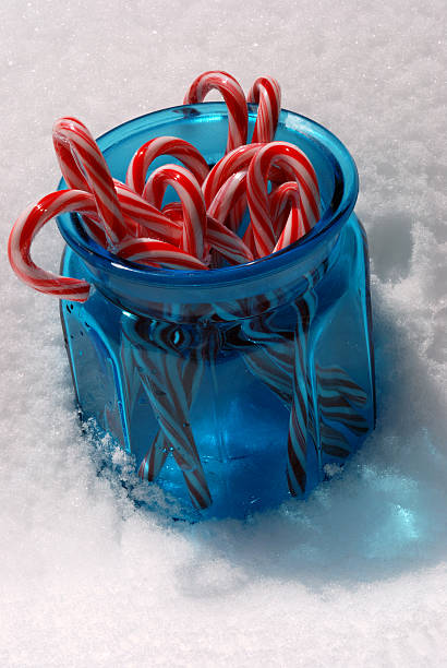 jar of candycanes in the snow stock photo