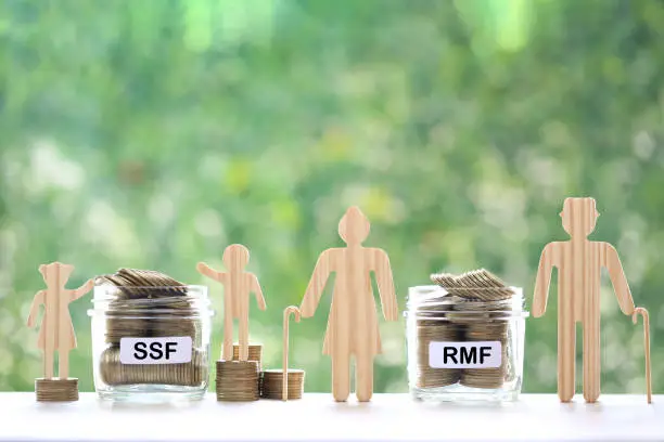 Model family with coins money in glass bottle on natural green background, SSF (Super Saving Funds) and RMF (Retirement Mutual Fund) concept