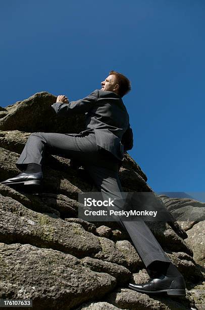 Young Man Businessman Climbing De Rock Face Precipicio Fiscal Foto de stock y más banco de imágenes de Acantilado