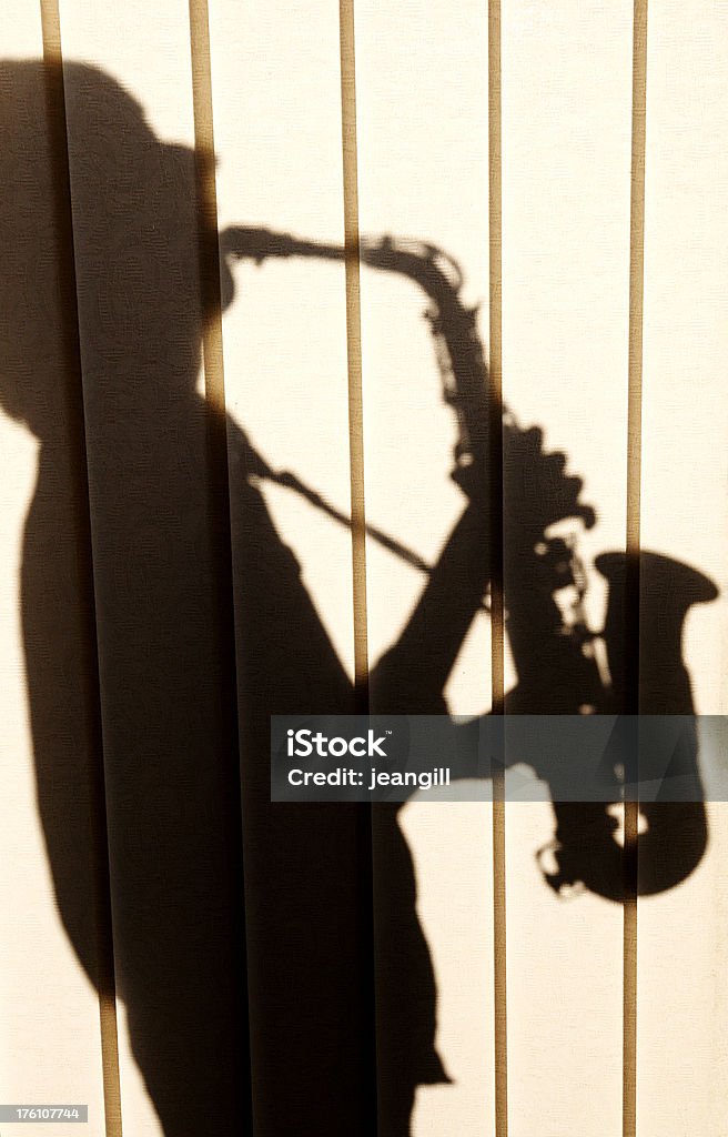 Shadow of Saxophonist ** Texture of blinds shows**shadow of young man playing saxophone backlit through Venetian blindsMore like this 14-15 Years Stock Photo