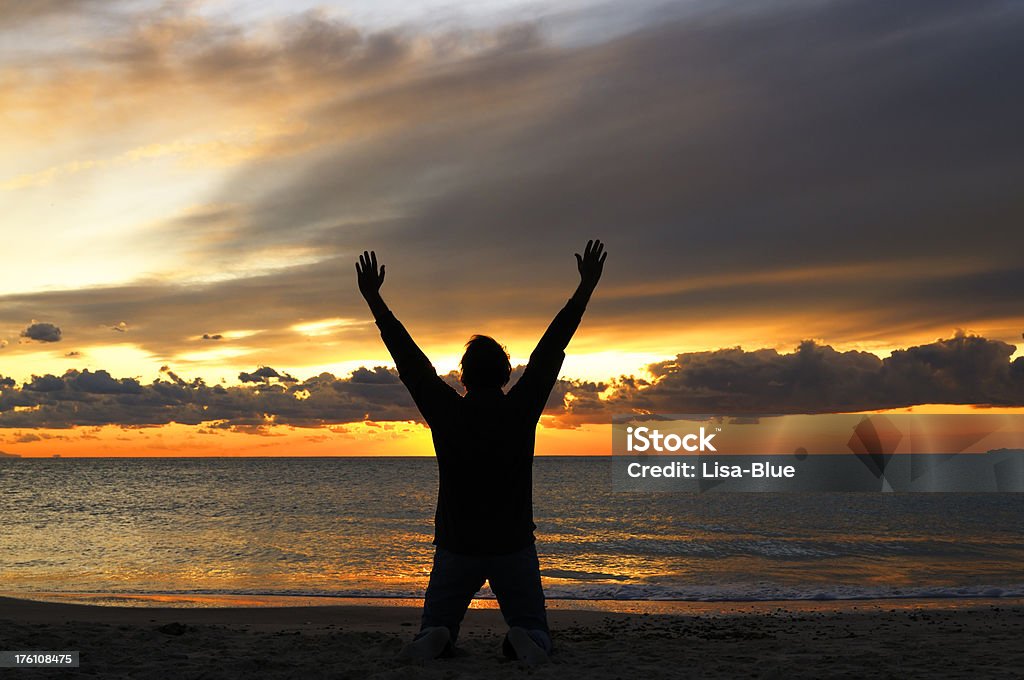 Hombre medida por el mar en la puesta de sol - Foto de stock de Aspiraciones libre de derechos