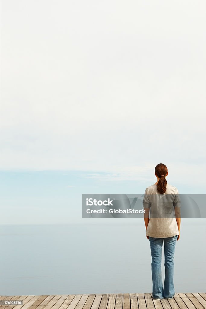 女性の方向を上に立つ海の桟橋 - 1人のロイヤリティフリーストックフォト