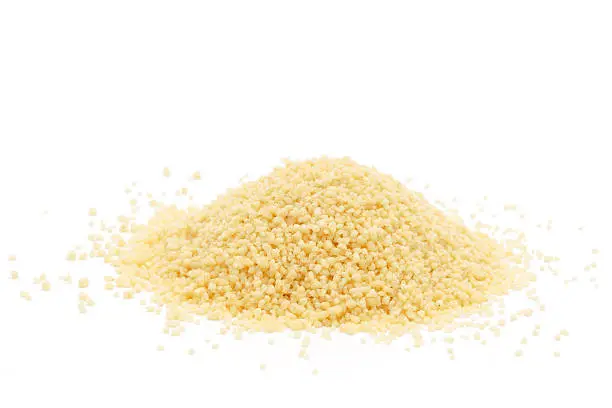 A pile of raw cous cous isolated on white.