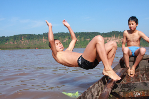 two boys swimming in the river