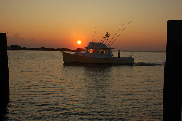 istock Boat returns to dock during yellow-orange sunset 176111065