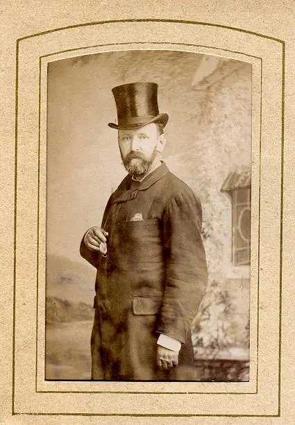 "Vintage photograph of a Victorian man cira. 1870 to 1880, wear a top hat and holding a pocket watch"