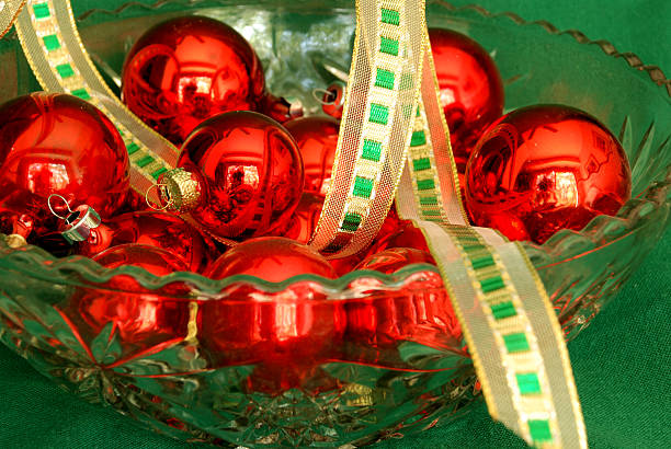 red ornaments and golden ribbon on green stock photo