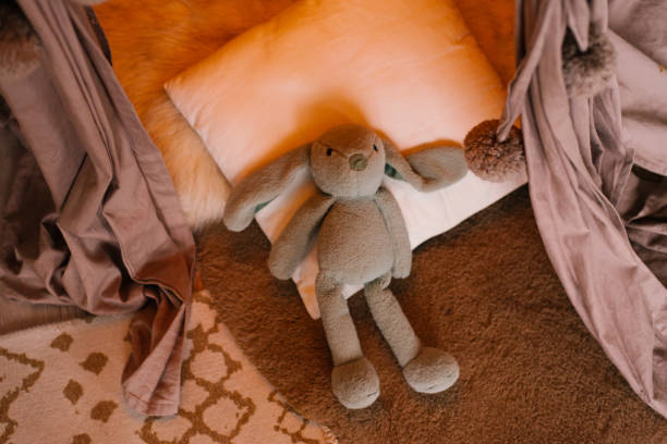 istock Cute toy rabbit lying in bed indoors 1761123618