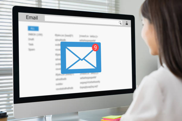 Businesswoman sitting using computer with checking email inbox on website.
