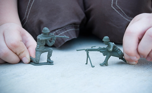 Child playing with army guys