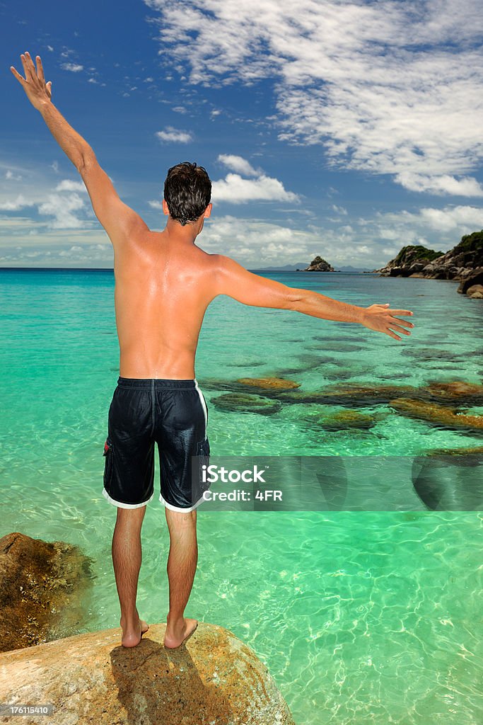 Uomo in piedi su una roccia, paradiso tropicale spiaggia (XXXL - Foto stock royalty-free di A petto nudo