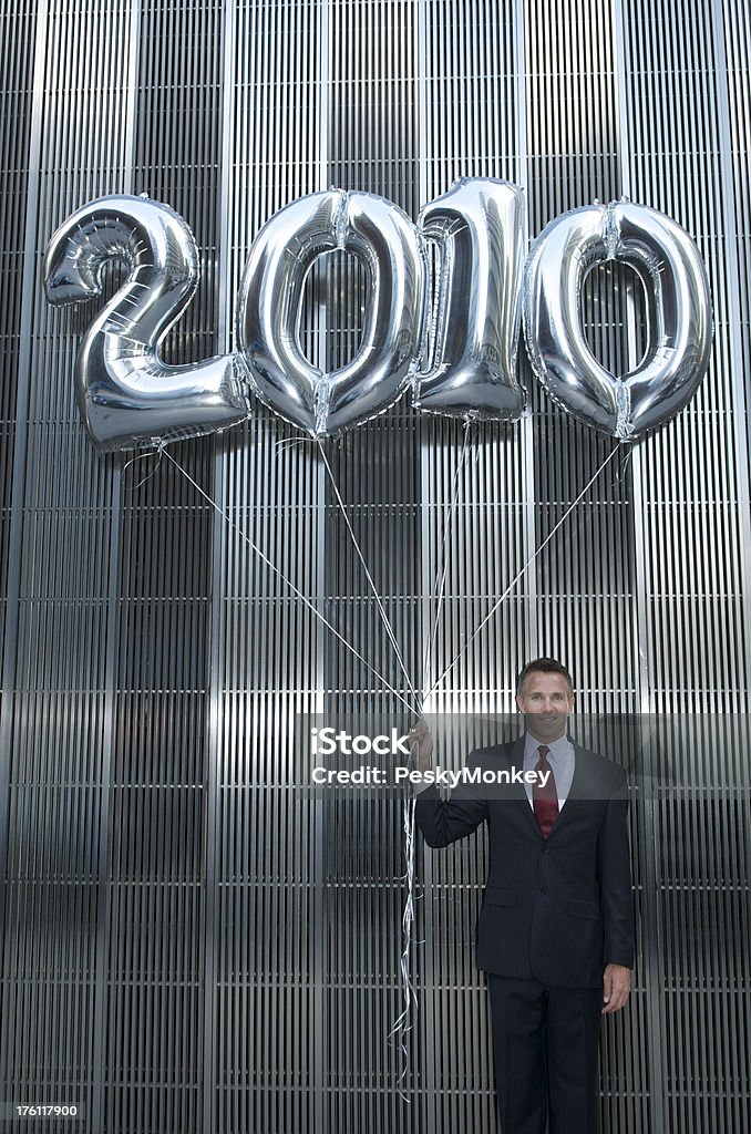 Empresário de pé com balões de prata brilhante de 2010 - Foto de stock de 2010 royalty-free