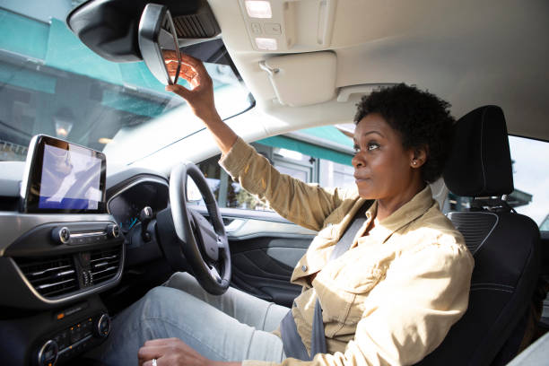 istock Female driver inside a car adjusting the rear view mirror 1761182995