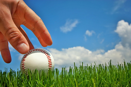 White leather baseball on hand.