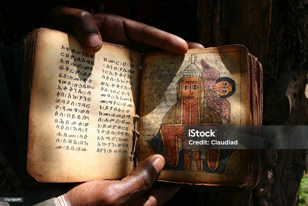 Old ethiopian bible Hands holding ancient bible with illustration.See my other pics of africa: Christianity Stock Photo