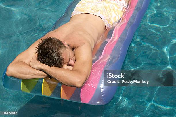 Guy Floats In Pool On Rainbow Lilo Stock Photo - Download Image Now - Adult, Copy Space, Dreamlike