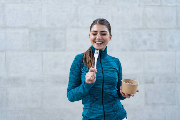 istock Beautiful woman eating fresh salad after intensive workout 1761204363