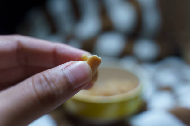 istock A hand takes salted peanuts or beans out of a ceramic cup. 1761204877