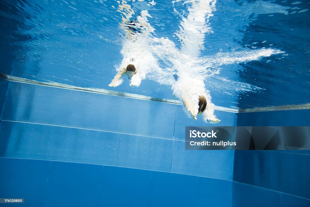 Vista subaquática de um jovem casal de saltar para a água - Foto de stock de 20 Anos royalty-free