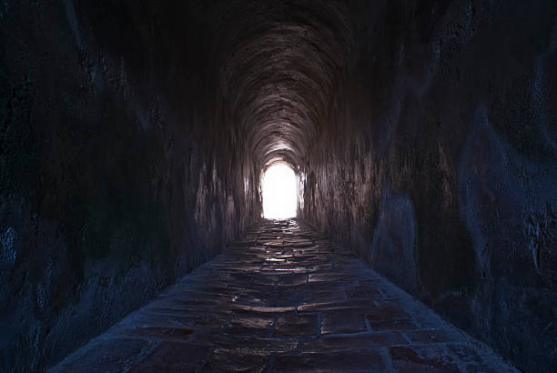 The light at the end of the tunnel. A tunnel leads out of a dungeon to briliant sunlight. The end of recession.