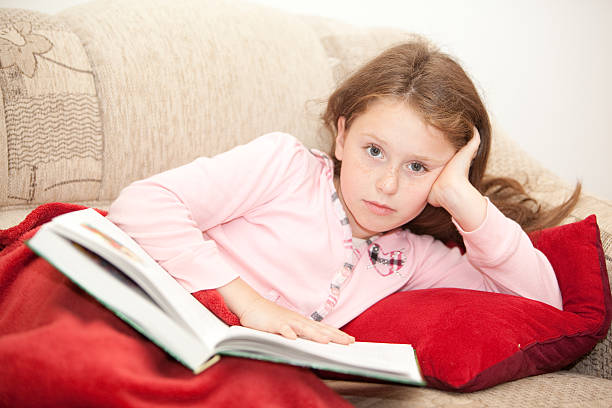 istock girl rest on sofa and reading the book 176121714