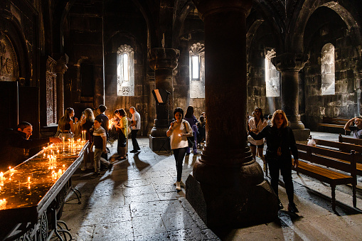 Goght, Armenia - September 30, 2023: visitors in Katoghike Church of Monastery of Geghard in Upper Azat Valley. Geghard is listed as UNESCO World Heritage Site