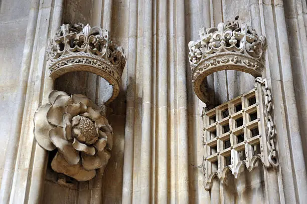 "Carved tudor (500 years old) stone Crowns, Rose (the heraldic badge of England) and portcullis on the walls of - King's College Chapel, Cambridge University, England"