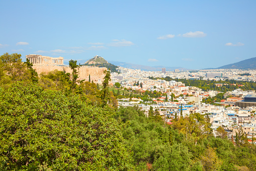 Greek flag on balcony against the Parthenon of Athenian Acropolis.